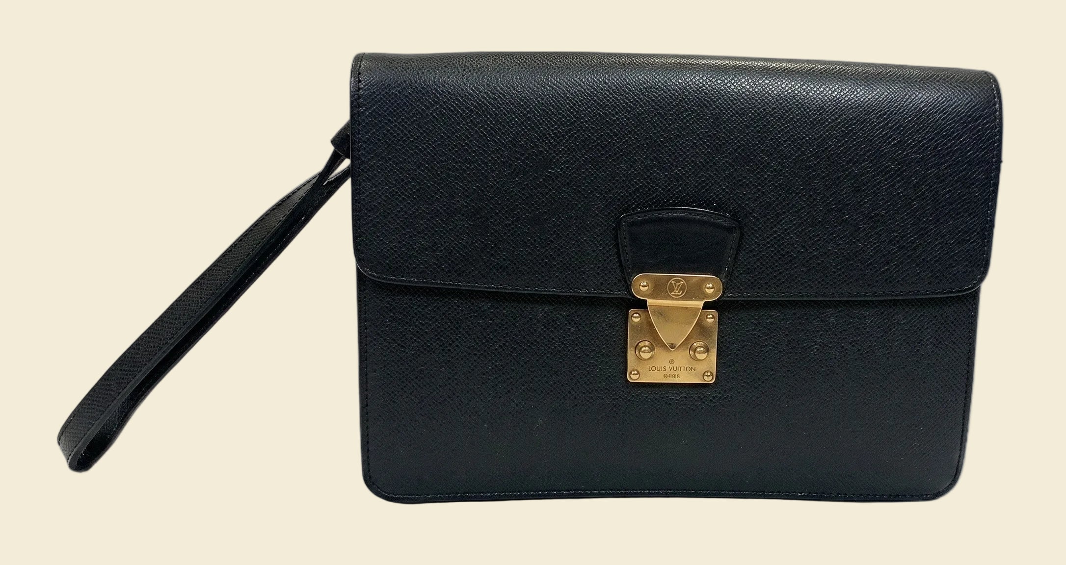 The Grand Tour Co. vintage Louis Vuitton Taiga leather Kourad wristlet clutch in black with gold-tone hardware.