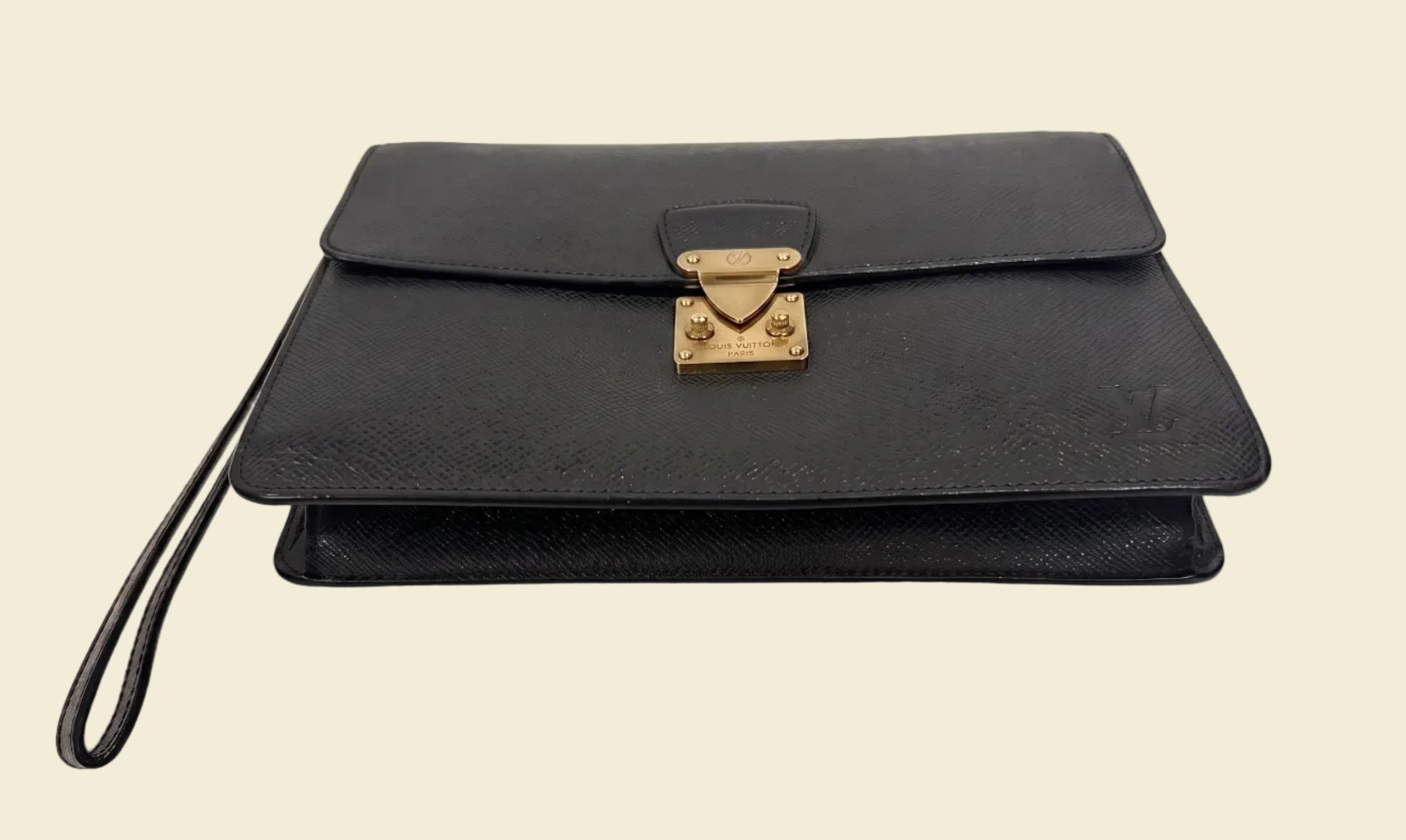 The Grand Tour Co. vintage Louis Vuitton Taiga leather Kourad wristlet clutch in dark green with gold-tone hardware.